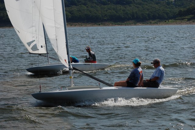 Two MC Scows sailing close together with crew aboard
